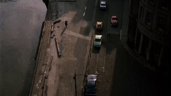 Movie still from “Get Carter” (1971), directed by Mike Hodges – An aerial view of a city street with cars parked on the side of the road; Extreme Wide shot, Overhead angle