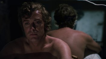 Movie still from “Get Carter” (1971), directed by Mike Hodges – A man sitting in front of a bathroom mirror; Close Up shot, Low angle