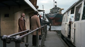 Movie still from “Get Carter” (1971), directed by Mike Hodges – A group of men standing on a dock next to a large ship; Extreme Wide shot, Over the shoulder angle