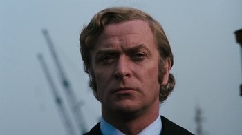 Movie still from “Get Carter” (1971), directed by Mike Hodges – A person wearing a suit and tie; Close Up shot, Low angle