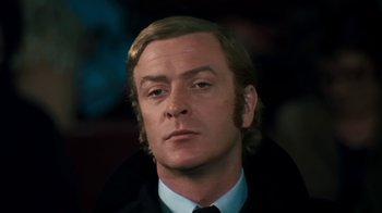 Movie still from “Get Carter” (1971), directed by Mike Hodges – A person wearing a suit and tie; Close Up shot, Low angle