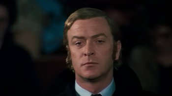 Movie still from “Get Carter” (1971), directed by Mike Hodges – A person wearing a suit and tie; Close Up shot, Low angle