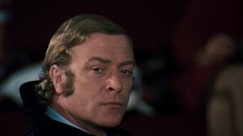 Movie still from “Get Carter” (1971), directed by Mike Hodges – A person wearing a suit and tie; Close Up shot, Low angle