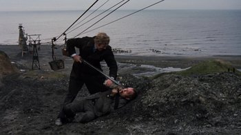 Movie still from “Get Carter” (1971), directed by Mike Hodges – Two men are fighting over a man laying on the ground; Wide shot, High angle
