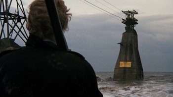 Movie still from “Get Carter” (1971), directed by Mike Hodges – A person in the water near a pier with power lines above it; Extreme Wide shot, Low angle