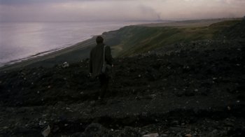 Movie still from “Get Carter” (1971), directed by Mike Hodges – A man standing on top of a hill looking out at the ocean; Extreme Wide shot, High angle