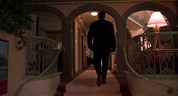 Movie still from “Get Shorty” (1995), directed by Barry Sonnenfeld – A man in a suit walking down a staircase; Wide shot, Low angle