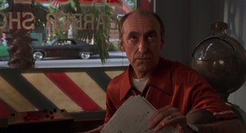 Movie still from “Get Shorty” (1995), directed by Barry Sonnenfeld – An older man holding a piece of paper in his hands; Close Up shot, Low angle
