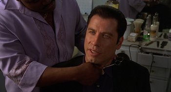 Movie still from “Get Shorty” (1995), directed by Barry Sonnenfeld – A man getting his hair cut by a barber; Close Up shot, Over the shoulder angle