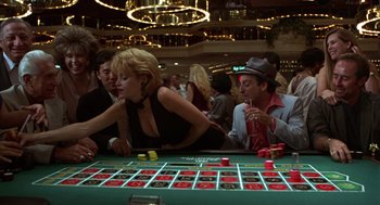 Movie still from “Get Shorty” (1995), directed by Barry Sonnenfeld – A group of people sitting around a roulette table; Medium shot, High angle