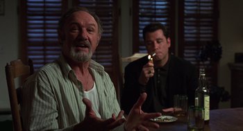 Movie still from “Get Shorty” (1995), directed by Barry Sonnenfeld – Two men sitting at a table with a lit candle in front of them; Medium shot, Low angle
