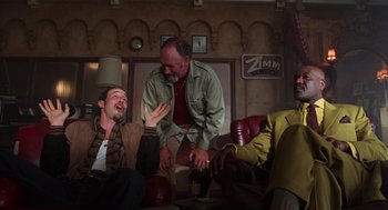 Movie still from “Get Shorty” (1995), directed by Barry Sonnenfeld – A group of people sitting around a room; Medium shot, Low angle