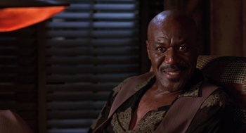 Movie still from “Get Shorty” (1995), directed by Barry Sonnenfeld – An older man is smiling for the camera; Close Up shot, Low angle