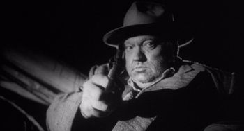 Movie still from “Get Shorty” (1995), directed by Barry Sonnenfeld – An old photo of a man holding a gun; Close Up shot, Low angle