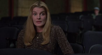 Movie still from “Get Shorty” (1995), directed by Barry Sonnenfeld – A woman with long blonde hair sitting in a chair; Medium shot, High angle