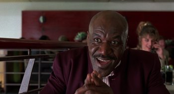 Movie still from “Get Shorty” (1995), directed by Barry Sonnenfeld – An older black man wearing a suit and tie; Close Up shot, Low angle