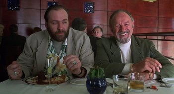 Movie still from “Get Shorty” (1995), directed by Barry Sonnenfeld – A couple of men sitting at a table with food; Medium shot, Low angle