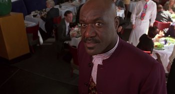 Movie still from “Get Shorty” (1995), directed by Barry Sonnenfeld – A man in a red jacket is posing for a picture; Close Up shot, Low angle