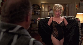 Movie still from “Get Shorty” (1995), directed by Barry Sonnenfeld – A woman in a black lace teddy is holding a jacket; Medium shot, Over the shoulder angle