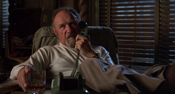 Movie still from “Get Shorty” (1995), directed by Barry Sonnenfeld – An older man sitting at a table talking on a phone; Close Up shot, High angle