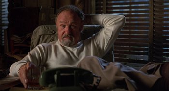 Movie still from “Get Shorty” (1995), directed by Barry Sonnenfeld – An older man sitting in a chair with his hand behind his head; Medium shot, Low angle