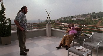 Movie still from “Get Shorty” (1995), directed by Barry Sonnenfeld – A man and a woman on a balcony with a view of a city; Wide shot, High angle