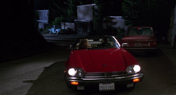 Movie still from “Get Shorty” (1995), directed by Barry Sonnenfeld – A woman driving a red car down a street at night; Wide shot, High angle