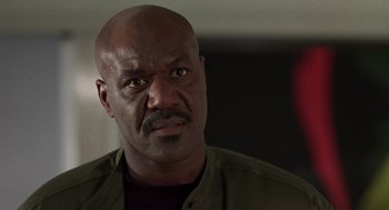 Movie still from “Get Shorty” (1995), directed by Barry Sonnenfeld – A bald man with a goatee stares into the camera; Close Up shot, Low angle