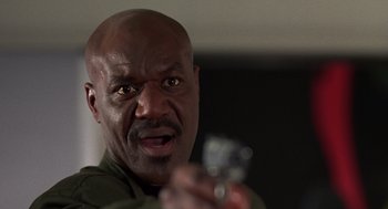 Movie still from “Get Shorty” (1995), directed by Barry Sonnenfeld – A bald man holding a gun in his right hand; Close Up shot, Low angle