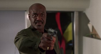 Movie still from “Get Shorty” (1995), directed by Barry Sonnenfeld – A man holding a gun in his right hand; Close Up shot, Low angle