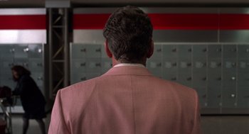 Movie still from “Get Shorty” (1995), directed by Barry Sonnenfeld – A man in a pink suit is standing in front of a row of lockers; Close Up shot, Low angle