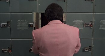Movie still from “Get Shorty” (1995), directed by Barry Sonnenfeld – A woman in a pink suit looking into a locker room; Medium shot, Over the shoulder angle