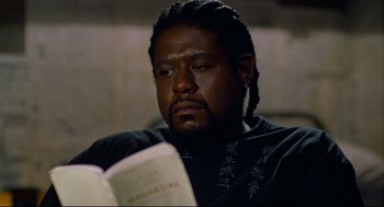 Movie still from “Ghost Dog: The Way of the Samurai” (1999), directed by Jim Jarmusch – A man with dreadlocks is reading a book; Close Up shot, High angle