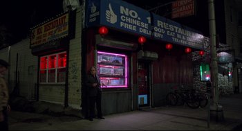 Movie still from “Ghost Dog: The Way of the Samurai” (1999), directed by Jim Jarmusch – A man standing in front of a chinese restaurant at night; Wide shot, High angle