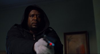 Movie still from “Ghost Dog: The Way of the Samurai” (1999), directed by Jim Jarmusch – A man in a black jacket holding a remote control; Close Up shot, Low angle