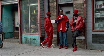 Movie still from “Ghost Dog: The Way of the Samurai” (1999), directed by Jim Jarmusch – A group of men standing next to each other on a sidewalk; Wide shot, Low angle