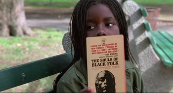 Movie still from “Ghost Dog: The Way of the Samurai” (1999), directed by Jim Jarmusch – A young girl holding a book in front of her face; Close Up shot, High angle