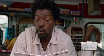 Movie still from “Ghost Dog: The Way of the Samurai” (1999), directed by Jim Jarmusch – A person sitting at a table; Close Up shot, Low angle