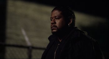 Movie still from “Ghost Dog: The Way of the Samurai” (1999), directed by Jim Jarmusch – A man in a black jacket is looking at the camera; Close Up shot, Low angle