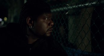 Movie still from “Ghost Dog: The Way of the Samurai” (1999), directed by Jim Jarmusch – A person with a chain link fence; Close Up shot, Over the shoulder angle