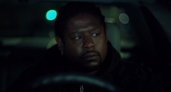 Movie still from “Ghost Dog: The Way of the Samurai” (1999), directed by Jim Jarmusch – A man sitting in the driver's seat of a car at night; Close Up shot, Over the shoulder angle