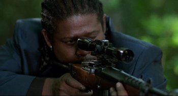 Movie still from “Ghost Dog: The Way of the Samurai” (1999), directed by Jim Jarmusch – A man with dreadlocks is holding a rifle; Close Up shot, Low angle