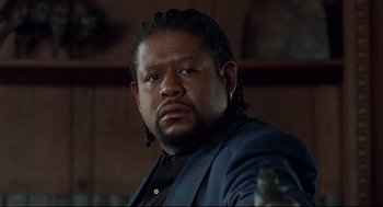 Movie still from “Ghost Dog: The Way of the Samurai” (1999), directed by Jim Jarmusch – A person wearing a suit and holding a gun; Close Up shot, Low angle