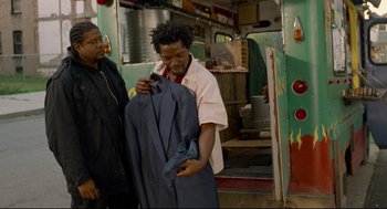 Movie still from “Ghost Dog: The Way of the Samurai” (1999), directed by Jim Jarmusch – A man holding a suit jacket in front of another man; Medium shot, Over the shoulder angle