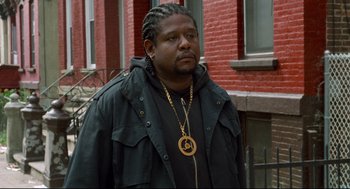 Movie still from “Ghost Dog: The Way of the Samurai” (1999), directed by Jim Jarmusch – A man standing in front of a red brick building; Close Up shot, Over the shoulder angle