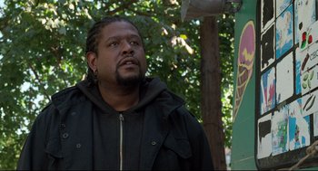 Movie still from “Ghost Dog: The Way of the Samurai” (1999), directed by Jim Jarmusch – A man standing in front of a tree looking off to his right; Close Up shot, Low angle