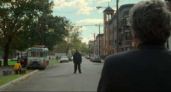 Movie still from “Ghost Dog: The Way of the Samurai” (1999), directed by Jim Jarmusch – A man standing on the side of the street; Extreme Wide shot, Over the shoulder angle