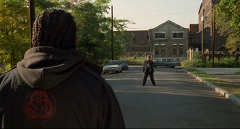 Movie still from “Ghost Dog: The Way of the Samurai” (1999), directed by Jim Jarmusch – A man standing in the middle of a street; Wide shot, Over the shoulder angle
