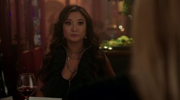 Movie still from “Emily in Paris” (2020), created by Darren Star – A woman sitting at a table in front of a mirror; Close Up shot, Over the shoulder angle