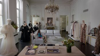 Movie still from “Emily in Paris” (2020), created by Darren Star – A living room filled with furniture next to a fireplace; Wide shot, High angle